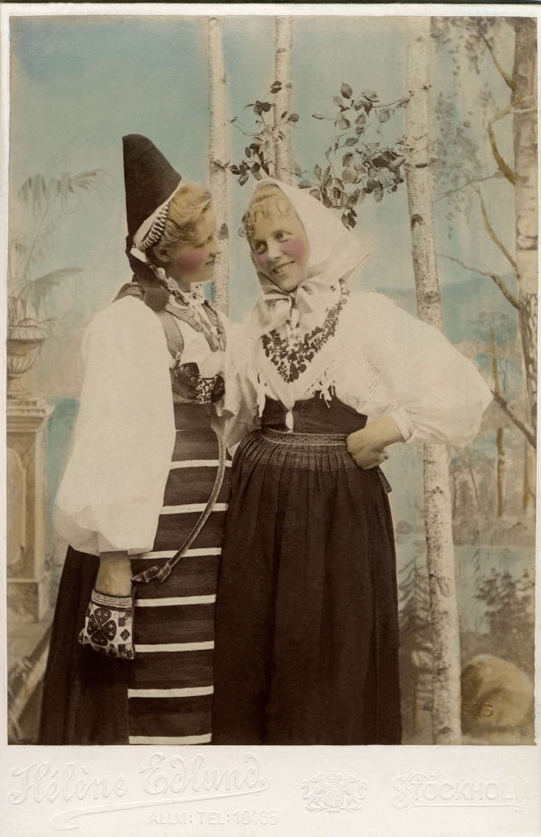 Färglagt foto efter ett kort på två unga flickor i folkdräkter