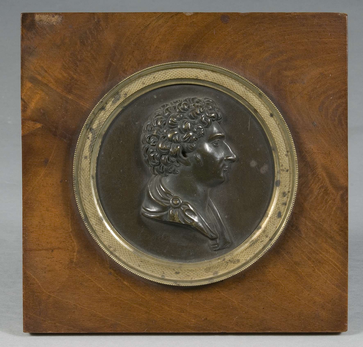 Rund bronsmedaljong med Karl XVI Johans profil.