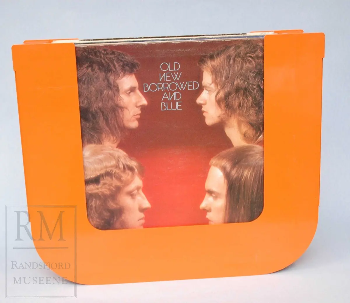 Platestativ i orange plast med plass til ca 20 LP-plater. Medfølger 17 plater.