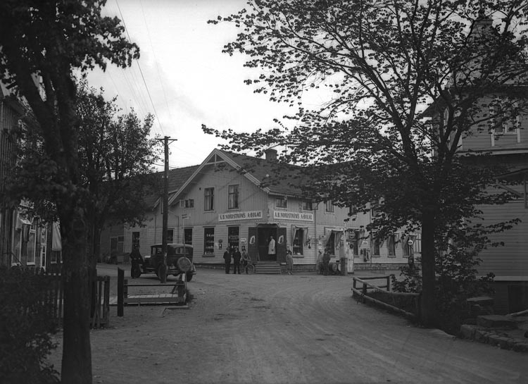 Enligt fotografens noteringar: "Affärscentrum omkring 1905. Innehavare AB Nordström bror till Hjalmar Nordström Ljungskile med en del vyer och andra därifrån."