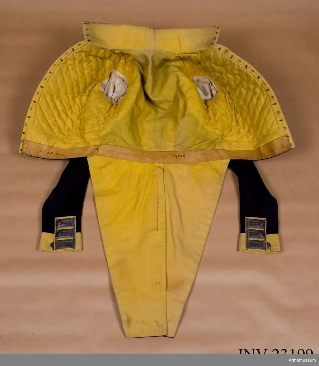 Frack av mörkblått kläde med gul bröstrevär, gul krage och gula ärmuppslag.