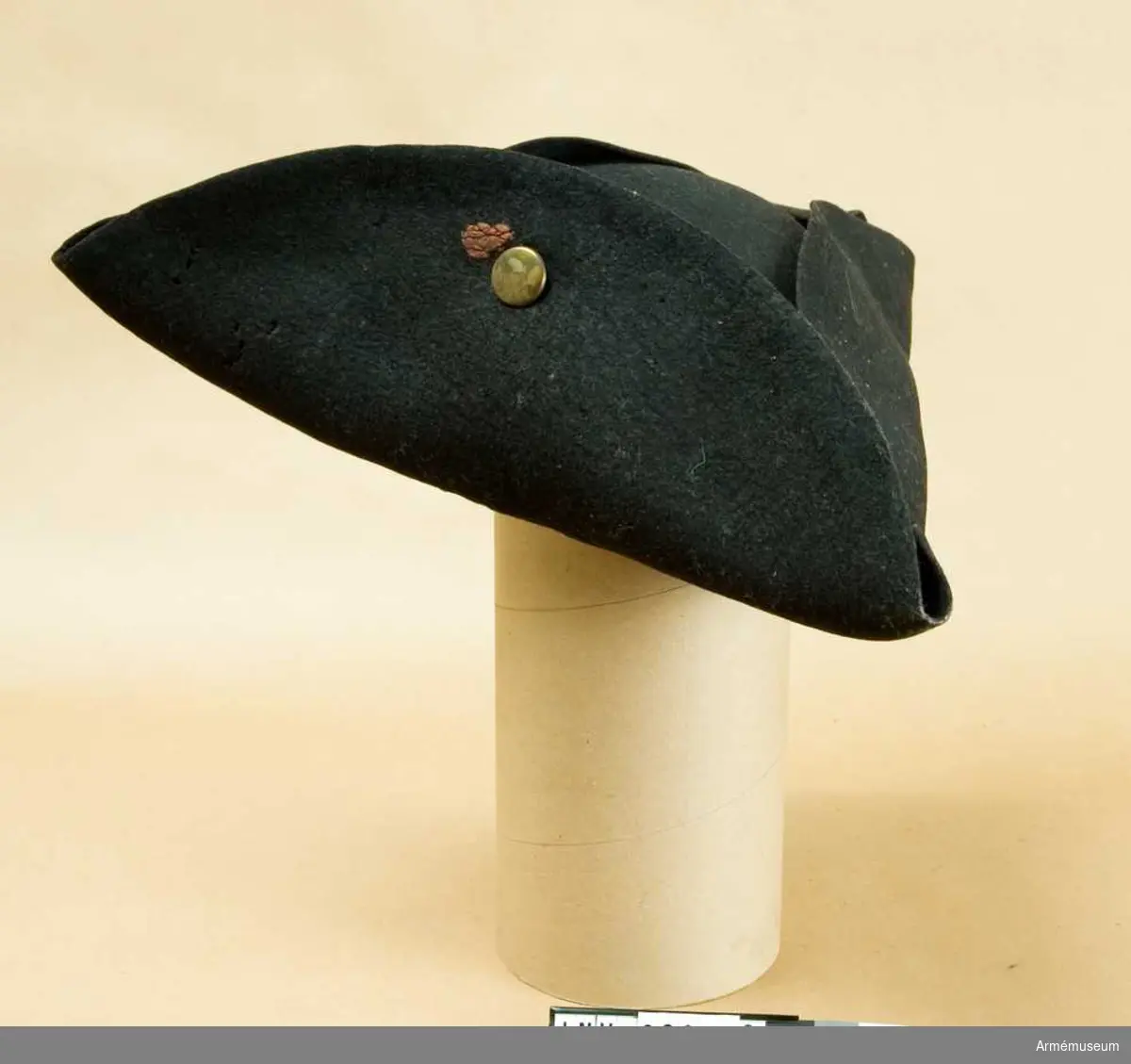 Grupp C I.
Trekantig svart hatt med mässingsknapp och rester av rött lacksigill.