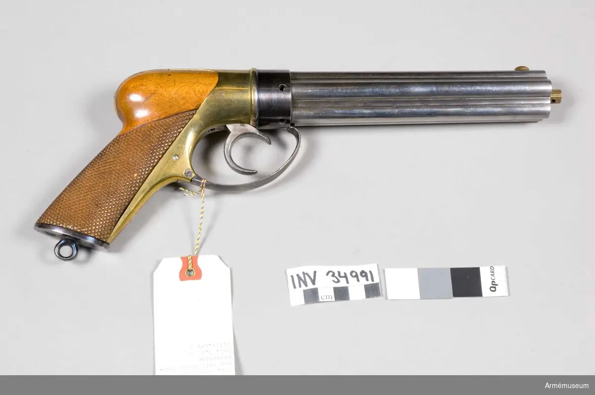 Grupp III d. 
Von Feilitzens konstruktion 1861, grundad på Colts system.Nr. 4 finns bakpå kolvbeslaget.

2008-02-15 EW
Piporna har fyra räfflor var. Dessa lossas genom att stången skruvas bort och pipknippet dras framåt tills spärrfjädern tar emot sedan vrids det motsols samtidigt som man drar lite framåt.

Tändhattsnipplarna är numrerade 6-10 vilket kan indikera att man haft ett pipknippe numrerat 1-5 för att snabbt kunna ladda om.
Nippel nr 10 liknar ej dom andra.

Kaliber 9,6 mm

Den "del" som tändhattsnipplarna går in i är numrerad 6 eller 9, denna del låses på sin plats av varbygeln. Den lossas genom att man drar den framåt och sedan nedåt. Vilket gör att delen kan skruvas bort. HÅLL avtryckaren lite spänd så att det ej tar emot!

Avfyrning fungerar genom att man spänner "hanen" med långfingret i avtryckaren och avfyrar genom att pressa den övre delen av avtryckaren med pekfingret, denna lyfts upp något när avtryckaren är i bakersta läget.

Hanen (eller slagstycket som Alm kallar det) är en rund skiva med ett uppstående segment vilket flyttas 1/5 varv vid varje avfyrning.

Att kalla detta "grundat på Colts system" av väl något oklart då piporna/pipknippet/trumman står stilla och det egentligen är hanen som roterar.

Fördelen med att ha nipplarna i bakändan, och inte vinkelrätt mot pipan som är det vanliga, är att vapnet blir smalt.

Enligt Alm provades vapnet 1863.

August Gustaf Reinhold von Feilitze var besiktningsofficer vid Husqvarna faktori 1852 och 1858. Han stämplade med initialerna RvF.