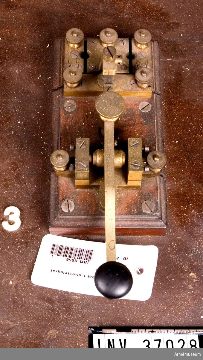Grupp H I. 
Monterad på träplint tillsammans med kopplingssegment och "polskruvar". Nyckeln företer stor likhet med Telefon A/B L M Ericssons nutida (1930-40-tal? reg.anm) telegrafnycklar för brandstationer och som dessa nycklar icke har blivit nämnvärt ändrade är det troligt att Lars Magnus Eriksson själv har utfört denna nyckel emedan han åren 1866-1872 arbetade hos Öller & Co.
Nr 173.