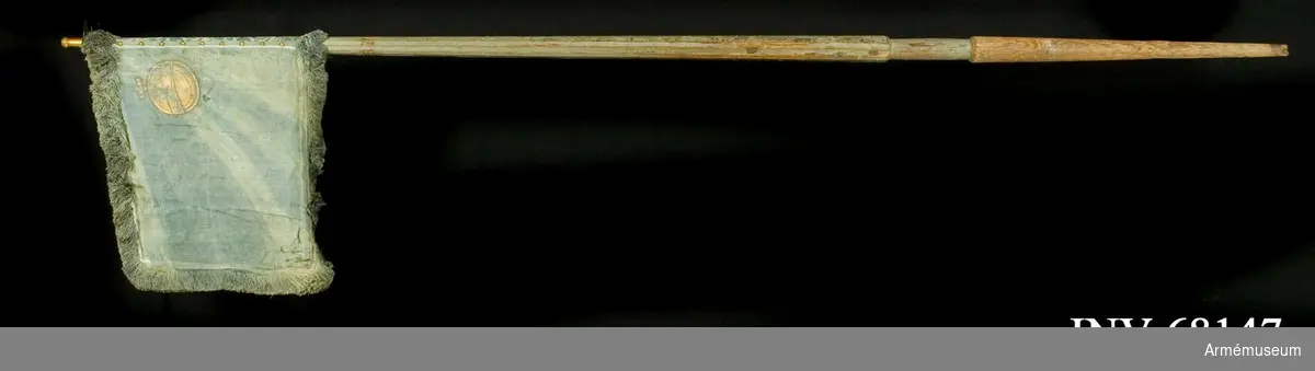 Duk:
Enkel, tillverkad av blå sidendamast. Duken fäst vid stången med tre rader höga tennlikor av mässing på blått mönstervävt band.

Dekor:
Målad i övre, inre hörnet, lika på båda sidor: ett riksäpple - Upplands vapen i brunskuggat guld.

Frans:
Tillverkad av blått silke.

Stång:
Tillverkad av trä, kannelerad, gråblåmålad. Holk av mässing, spets saknas. Löpnit(?).