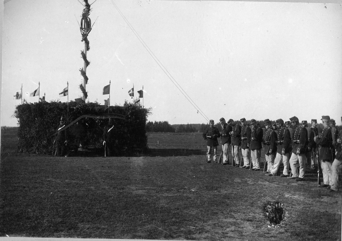 Soldater ur Älvsborgs regemente I 15 i framför omkringbyggd majstång på Fristad hed.