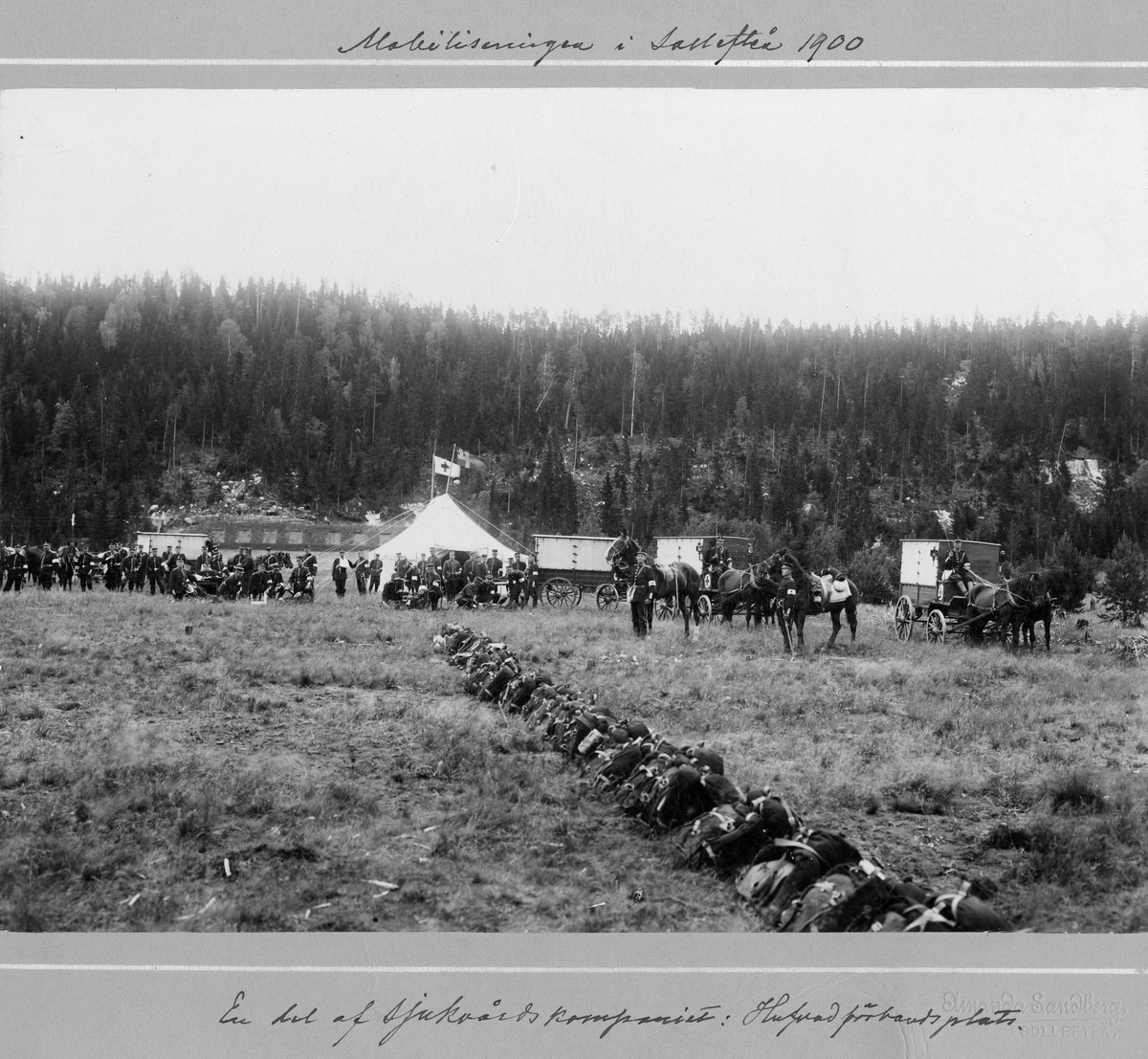 En del av sjukvårdskompaniet vid Västernorlands regemente I 28, övar vid Hutvad förbandsplats under mobiliseringen i Sollefteå 1900. I bakgrunden syns sjukvårdstält och sjukvårdskärror dragna av hästar.