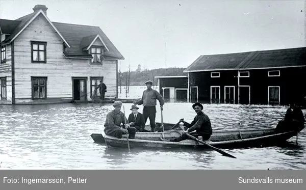 Från översvämningarna vid vårfloden 1919. Okänt var men troligen någonstans i Selånger. Selångers kyrka kan anas mellan husen.