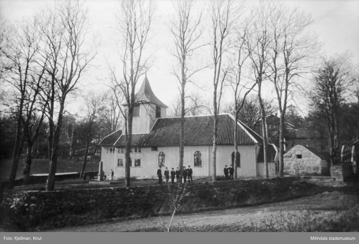 Råda kyrka i Mölnlycke med folk utanför på gårdsplanen.
Publicerad i Johan Lundskogs bok "Fässbergs socken och Mölndals kvarnby".
