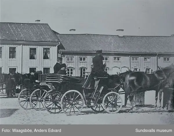 Droskor med kuskar och passagerare på Stora torget. Rådhuset efter branden 1803, till vänster det så kallade "Forsstedska huset"  var rådhus till 1867 då det nuvarande togs i bruk.