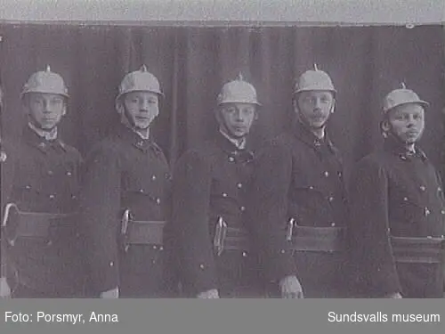 Fem av bröderna Englund (Leander, Thure, Thor, Johannes, Helge) som brandsoldater i S-valls Brandkår. Firman "Englunds" tillverkade brand--hjälmar i aluminium för S-valls brandkår.