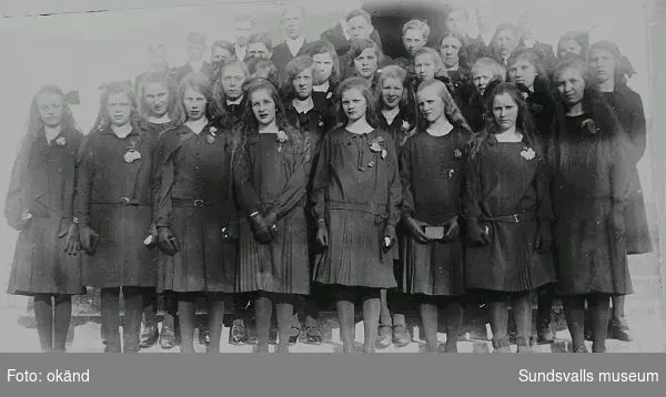 Konfirmationsgrupp, läsbarn, på trappan till Lidens kyrka, 1928. Som fyra från höger i andra raden nerifrån tittar Siri Norén (f. 1914, gift Edblad) fram. Konfirmationspräst var kontraktsprosten Lars Hoflin.