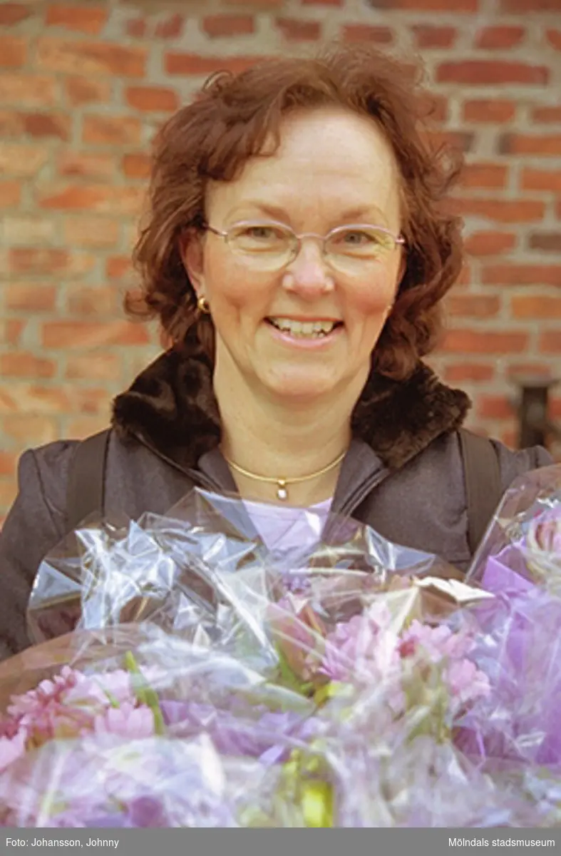 Kvarnbydagen 28 april 2002. Kultursekreterare Gudrun Piculell står beredd att dela ut blommor till dansarna av ForsAnde. I bakgrunden ses Stora Götafors.