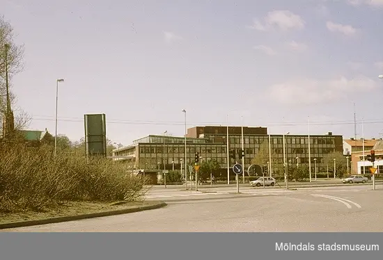 Rondellen mot Göteborgsvägen västerut, mars 1993. I fonden ses Stadshusplatsen och Mölndals stadshus. Relaterade motiv: 2003_0386 - 0387.
