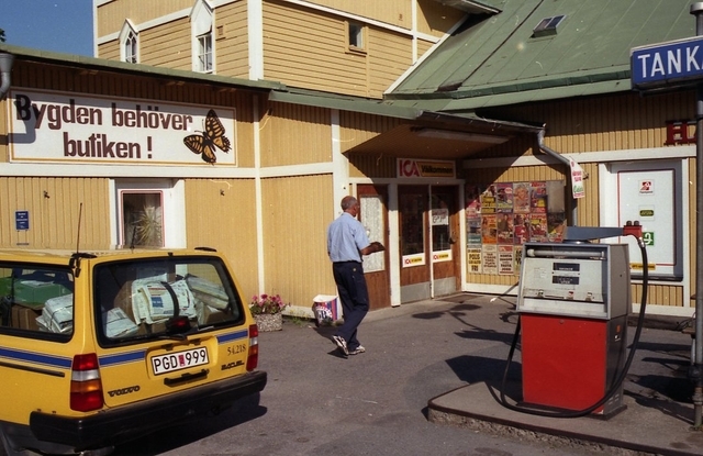 Lantbrevbärare Reinhold Andersson delar ut post till en butik.
Tillhör en dokumentation av en lantbrevbärare i trakten av
Valdermarsvik av fotograf Ove Kaneberg.