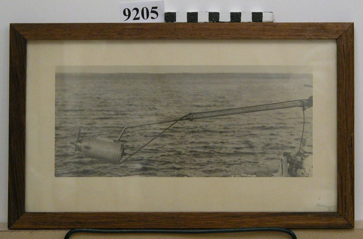 Fotografi inom glas och ram, Ramen av ek. Visar stångtorped på stång från sidan av ett fartyg.