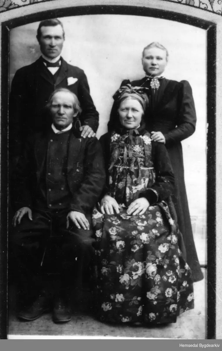 Framme frå venstre: Ola T. Flaget, fødd Rustad, 1828-1916, gift med Anne Anderdal (1833-1912).
Bak frå venstre: Tore Flaget og Sigrid Flaget, seinare gift med Ola Flaget nordre.