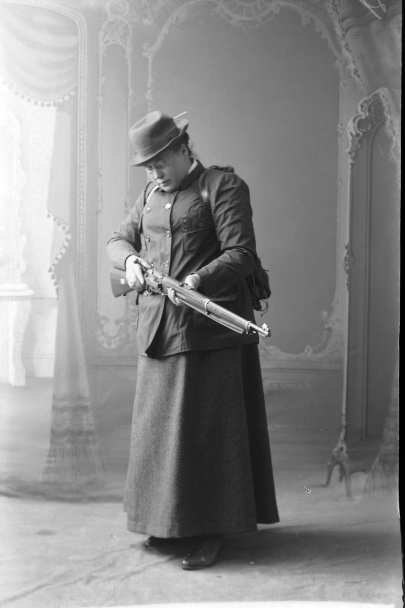 Anna Bertheussen fotografert med en Krag Jørgensen-rifle  i studio hos Magdalene Norman.
