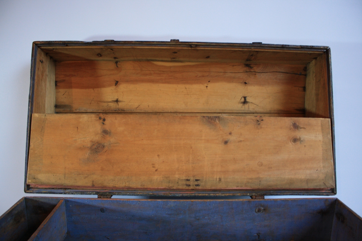 Gråblå kiste med bua lok og metallbeslag. Har ein leddik utan lok. Hengsla bunn av loket som gir eit oppbevaringsrom (målt oransje). Kjem frå rom 2 i Ausevika.