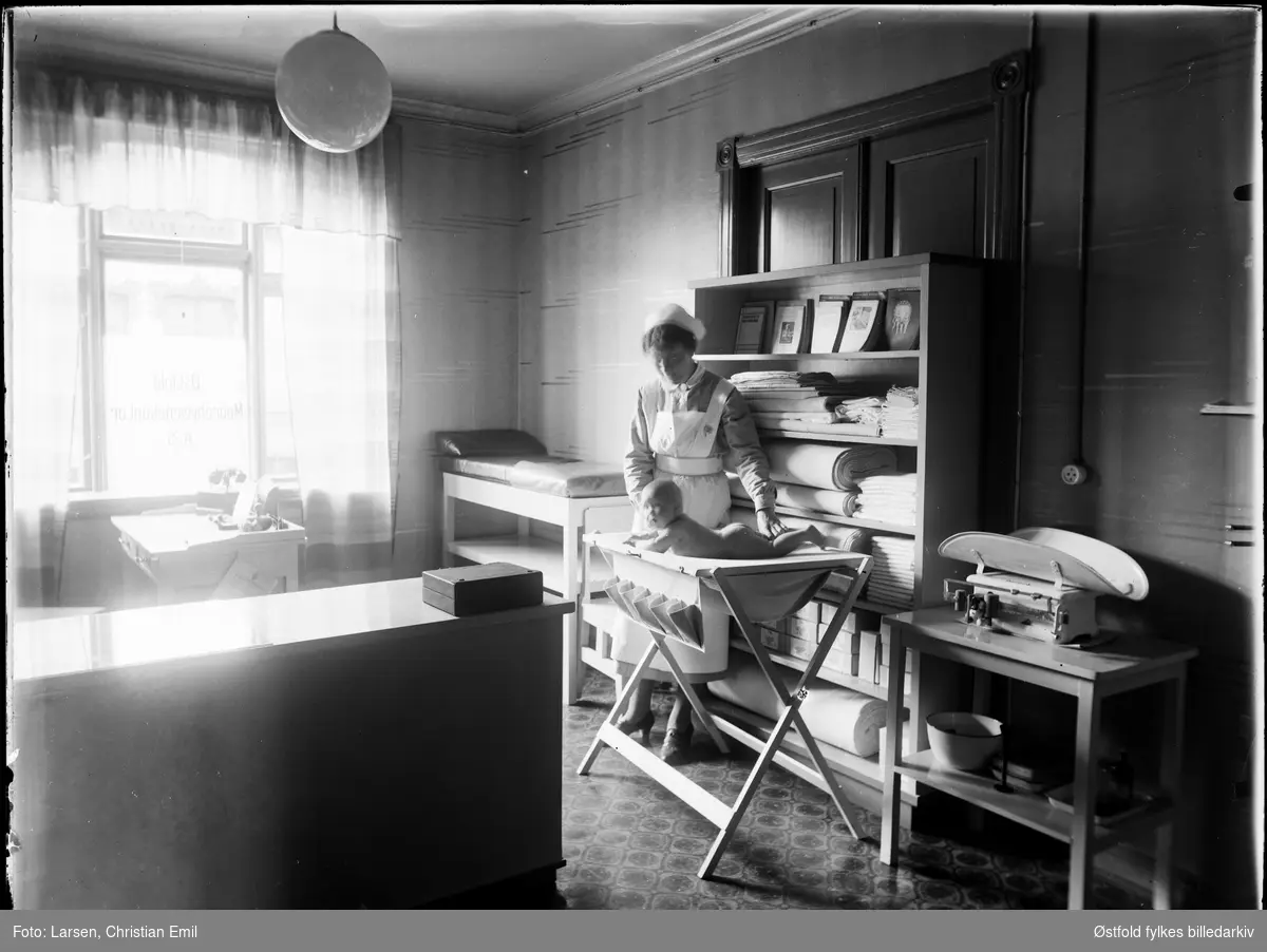 Østfold føde- og barselhjem, etter 1935. 
Spebarnskontroll, sykesøster, kontor, stellebarn, spebarnsvekt, hørerør,