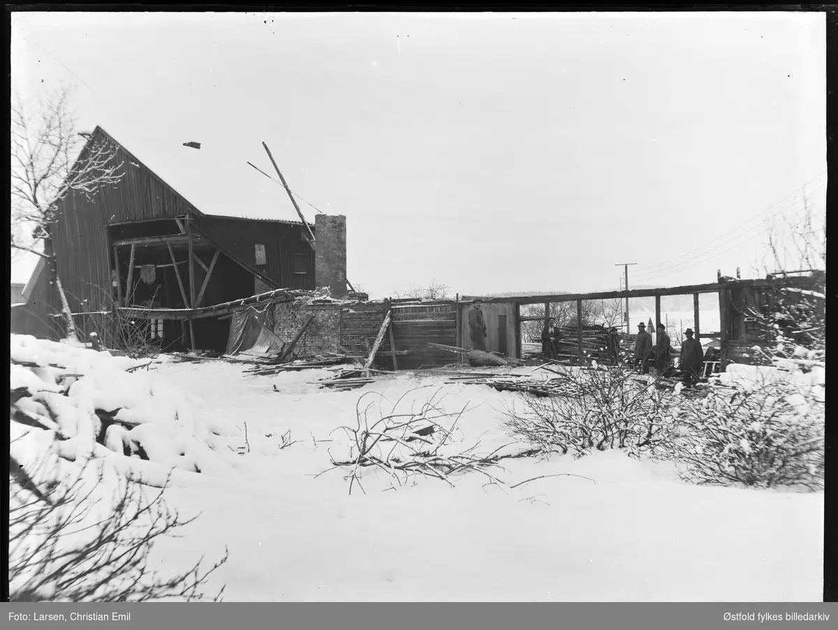 Riving av garveriet i Glengsgata 14 i Sarpsborg januar 1927.  Sarpsborg jernbanestasjon og tømmerkrana på Opsund i bakgrunnen.
Ukjente personer.