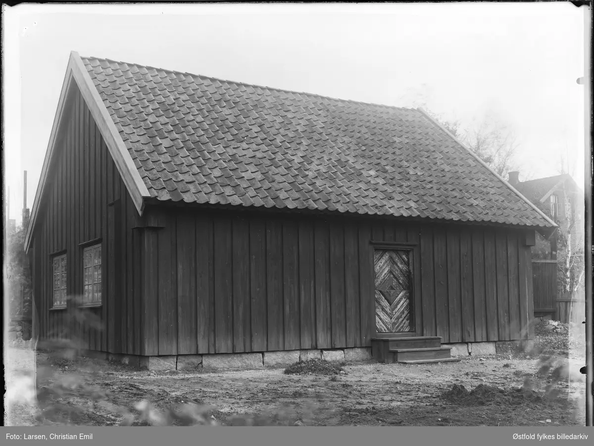 Borgarsyssel Museum, husmannsstue, eksteriør, oppført på museet 1934.
Husmannsstua var opprinnelig en plass under Hafslund hovedgård i Skjeberg, den hette Nesset. Stua var bygd på midten av 1800-tallet, og var stor til å være en husmannsplass, den var en såkalt bruksarbeideplass.

I bakgrunnen skimtes en av ingeniørboligene til Borregaard som lå i Borregaardsveien, denne er nå revet. (Omtrent der Wegenerbrakka ligger i dag).