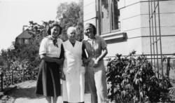 Tre kvinner utenfor en murbygning (antatt studentbolig, samm