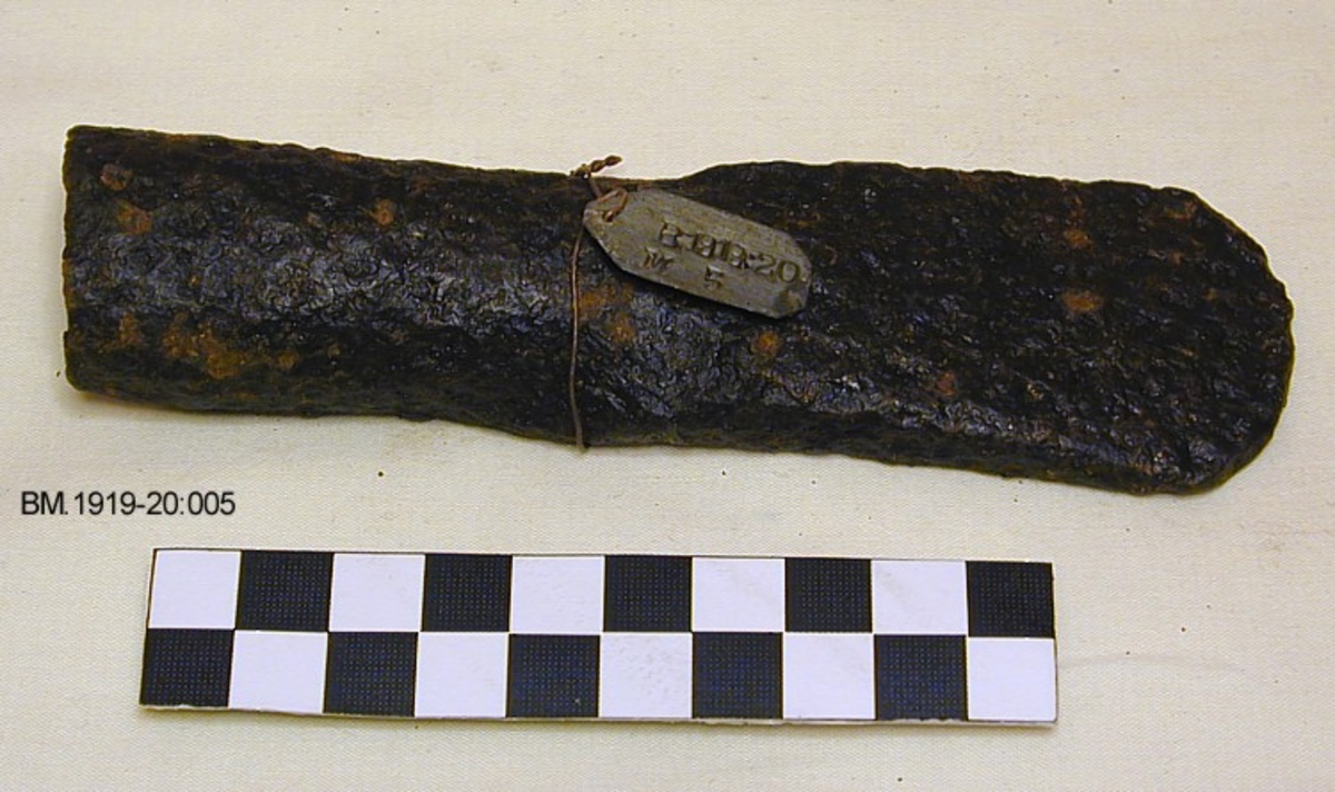 Celt av jern, nærmest av form som Jan Petersen: Vikingetidens redskaper, fig.96, med nesten lukket fal, jevnt utsvinget blad og svært butt egg.