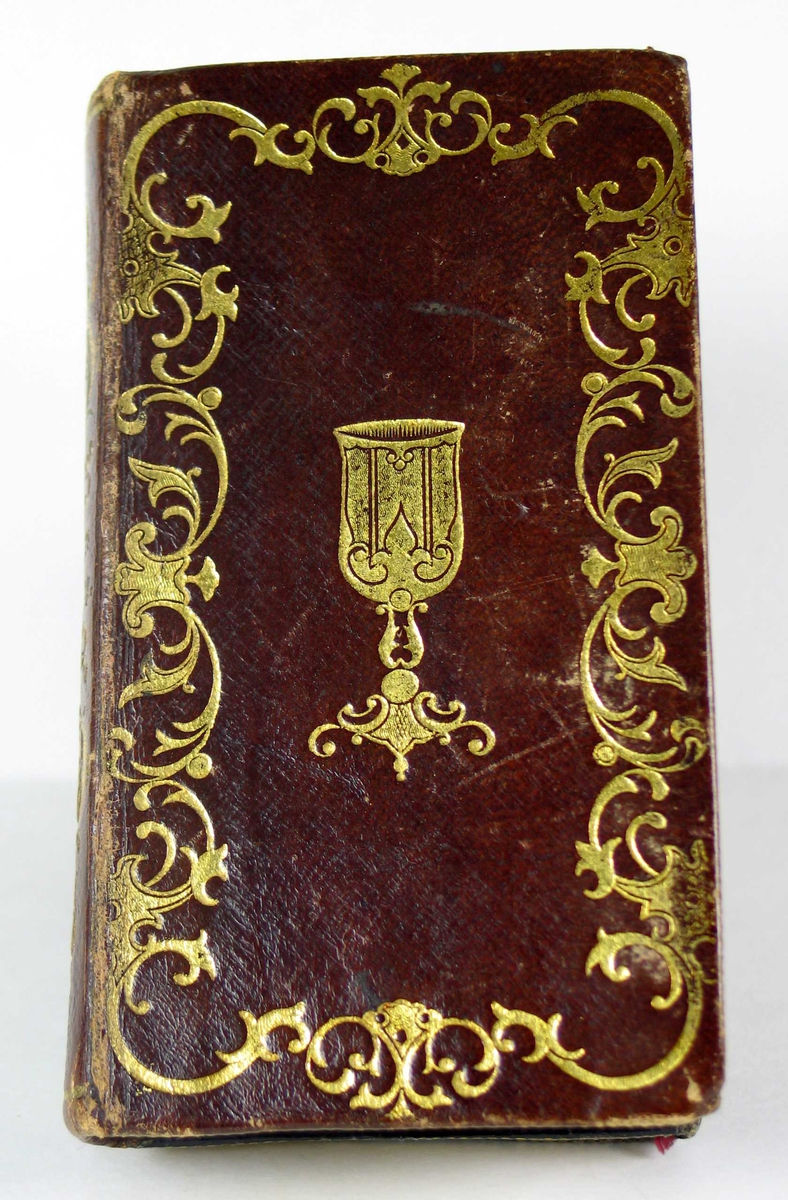 To bøker satt sammen: Salmebok og evangelier i brunt skinn med gullsnitt.
