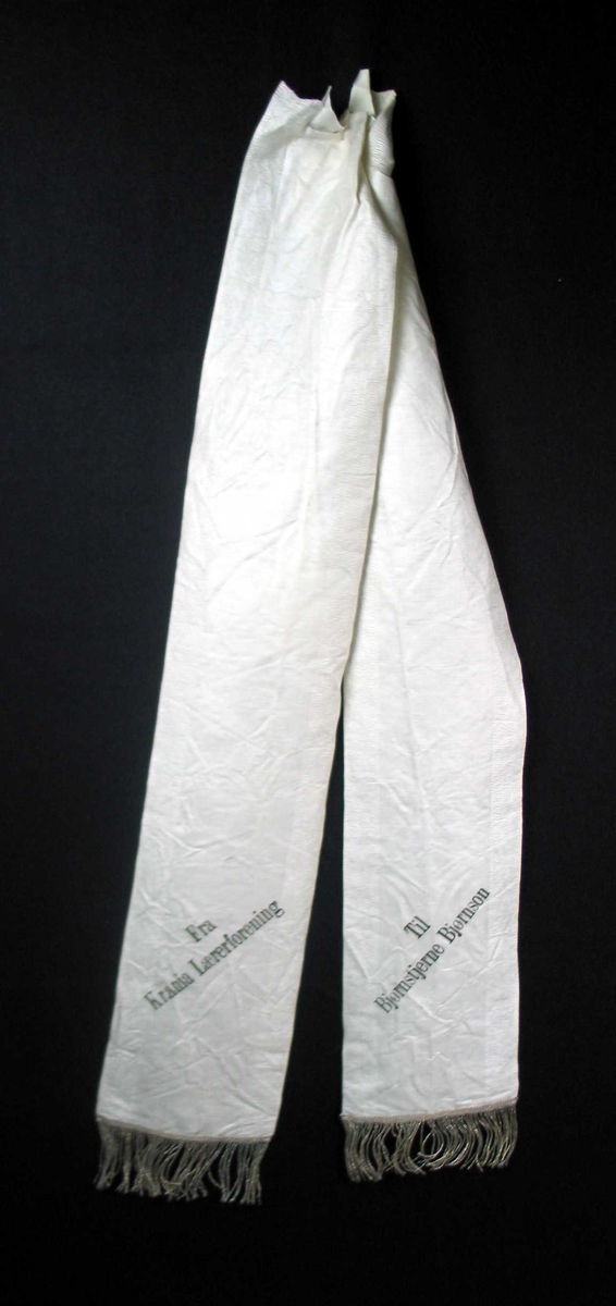 Begravelsessløyfe i hvit silke med frynser.