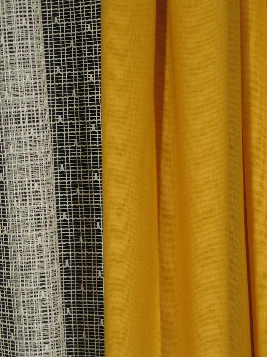 Et fag gule gardiner i to-skaft ullstoff.