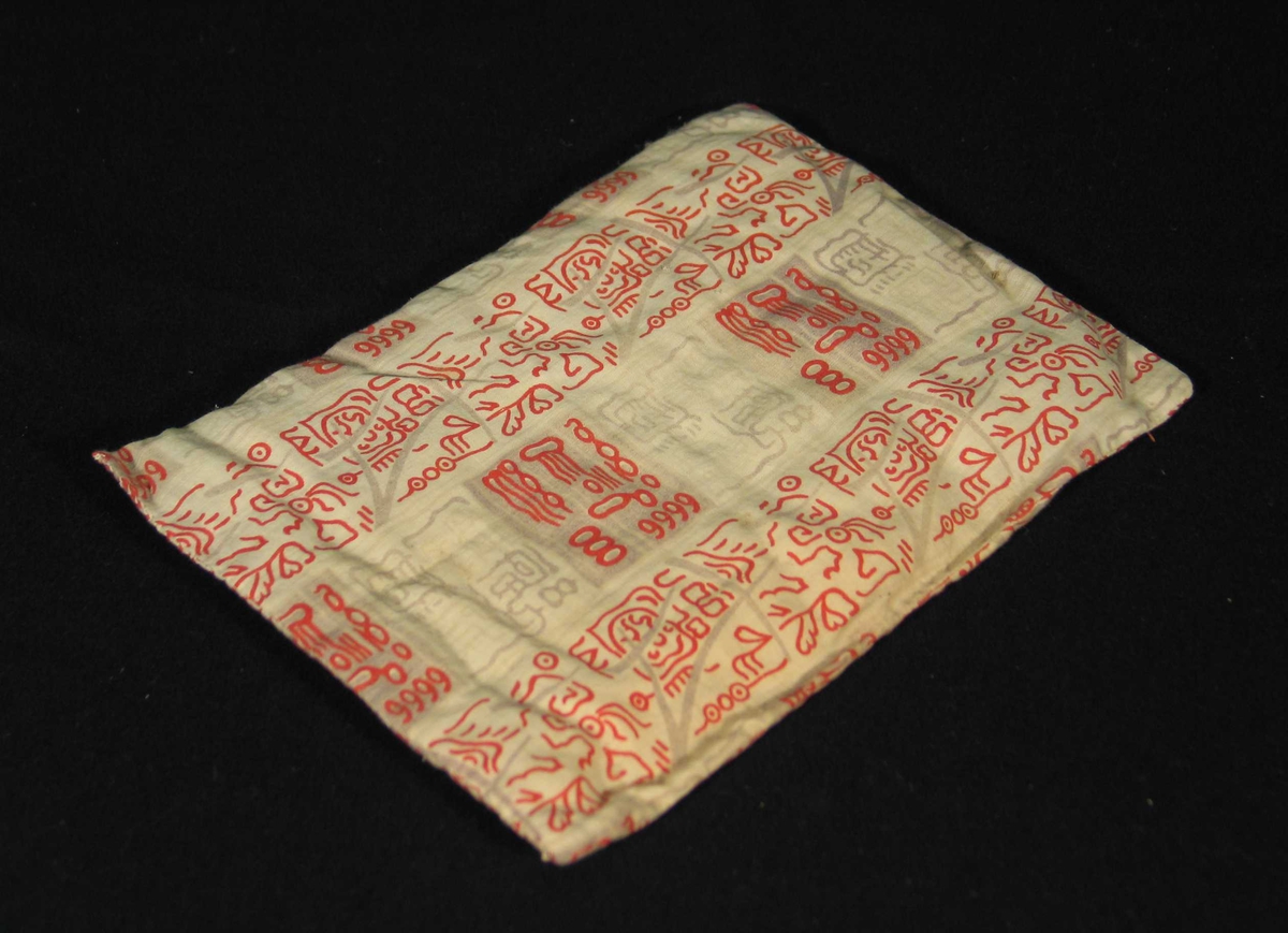 Vattert madrass til dokkeseng i mønstret rødt bomullsstoff.