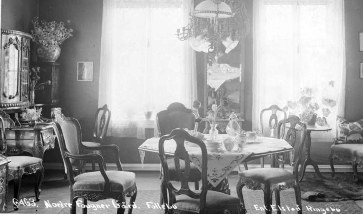 Gausdal. Follebu. Nordre Fougner gård. Rundt bord med stoler, taklampe, konsollspeil, veggskap.