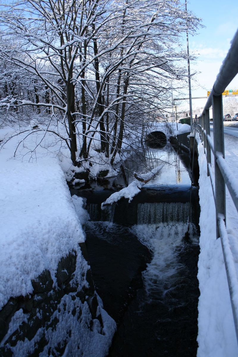 Langsæ hovedstem. Ved Barbuelva, Mellom Klokkebua og Riksvei 410 t.h. Snødekket vinterlandskap. Denne terskelen regulerer vannivået i Langsævannet. 