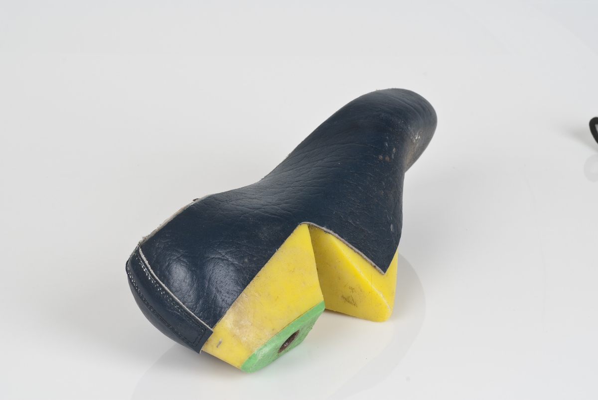 En plastlest med overlæret til støvel (fabrikkstøvel).
Plastlesten er i fargen gul.
Høyrefot i skostørrelse 44, med 7,5 cm i vidde.
Skinntrekket er i blåfarge.
Lestekam av plast i grønnfarge.

