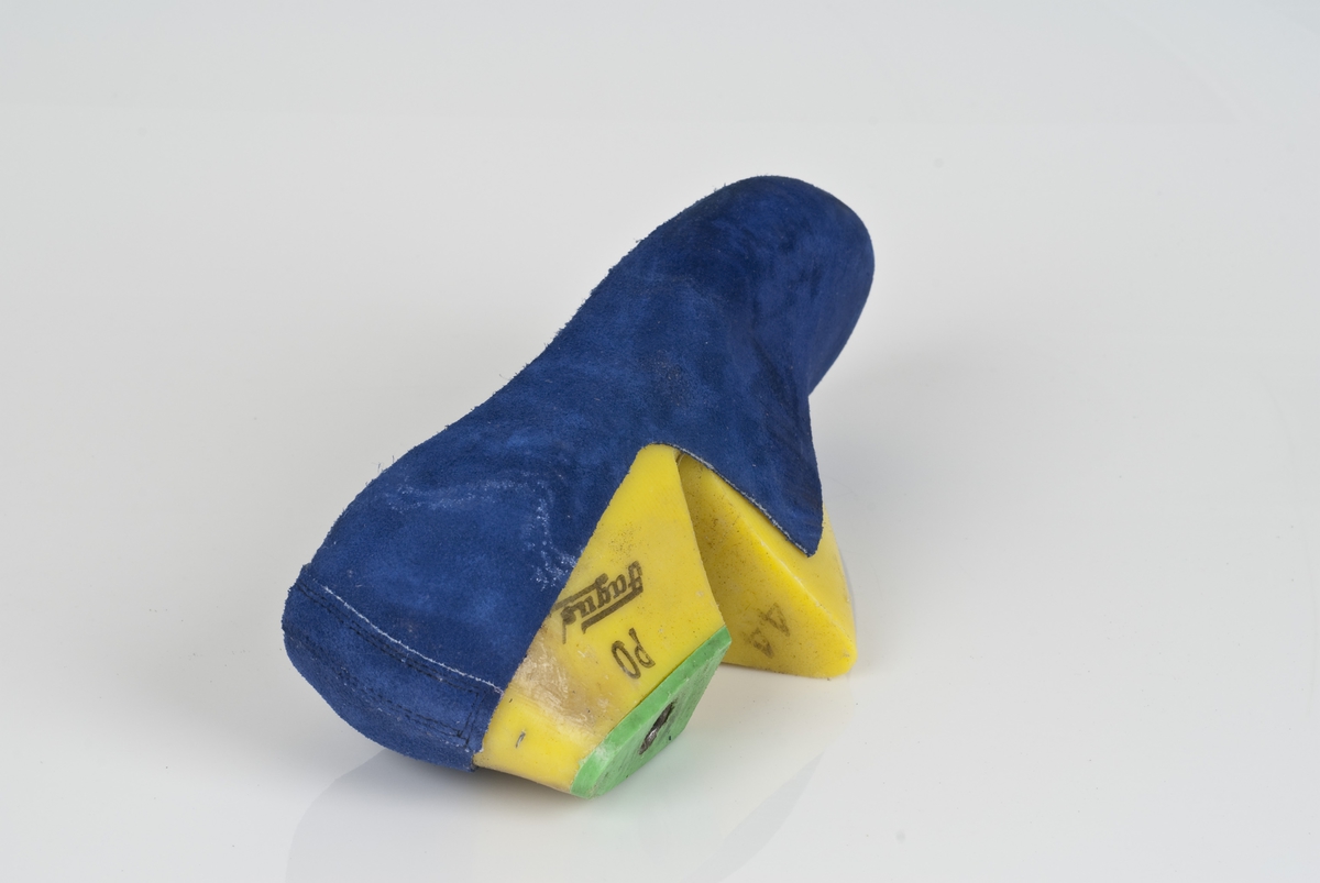 En plastlest med overlæret til støvel (fabrikkstøvel).
Plastlesten er i fargen gul.
Venstrefot i skostørrelse 44, med 7,5 cm i vidde.
Skinntrekket er i blåfarge.
Lestekam av plast i grønnfarge.

