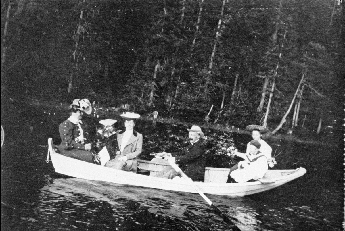 2 kvinner, 3 barn og en mann som rori robåt. Mennesker fra Losby.