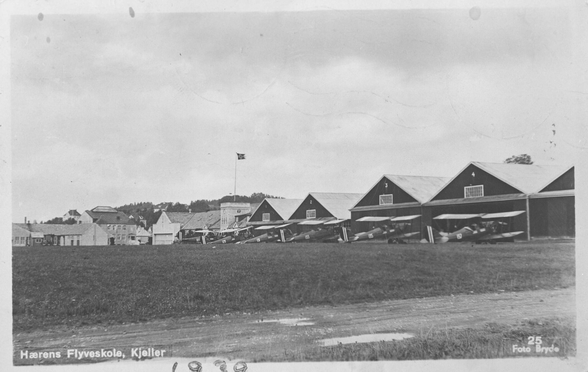Hærens flyveskole på Kjeller m/oppstilte fly foran hangarene.