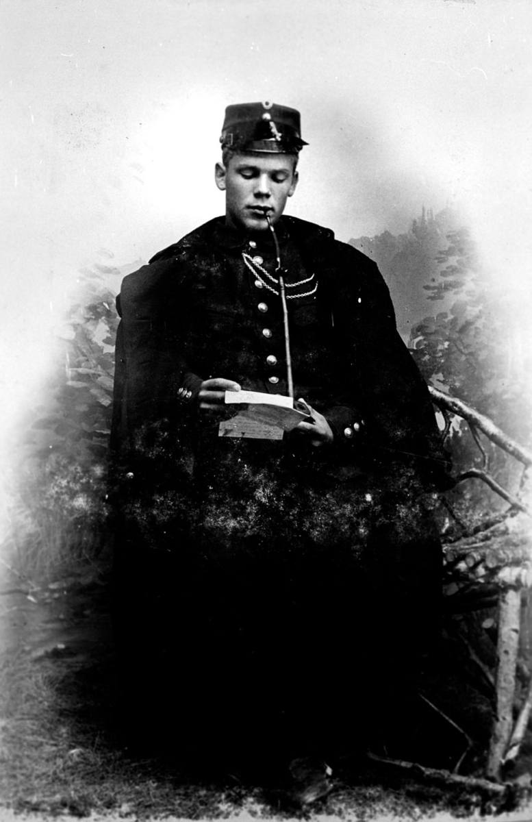 Soldat som røker langpipe og leser et brev.