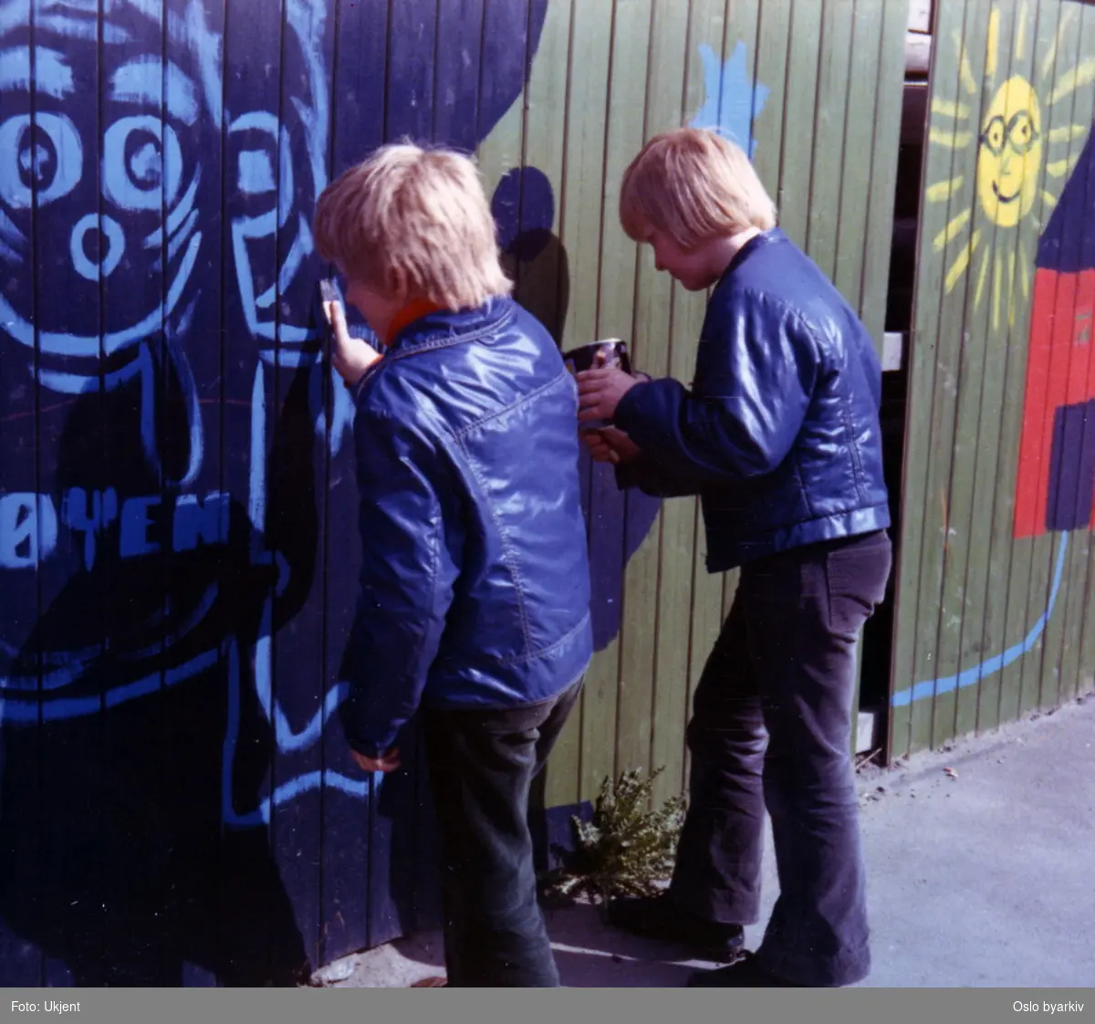 Barn fra Tøyen Juniorklubb dekorerer / maler på plankegjerde langs Kjølberggata. Fra "Aksjon Spire 1973".