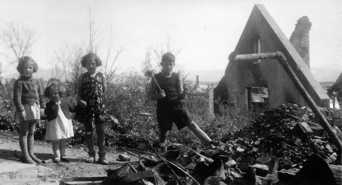 Banken i bakgrunnen..En barneflokk på fire fra Oslo på sin onkel Johannes Øverlands branntomt i Parkveiein 16 i Molde 1940.