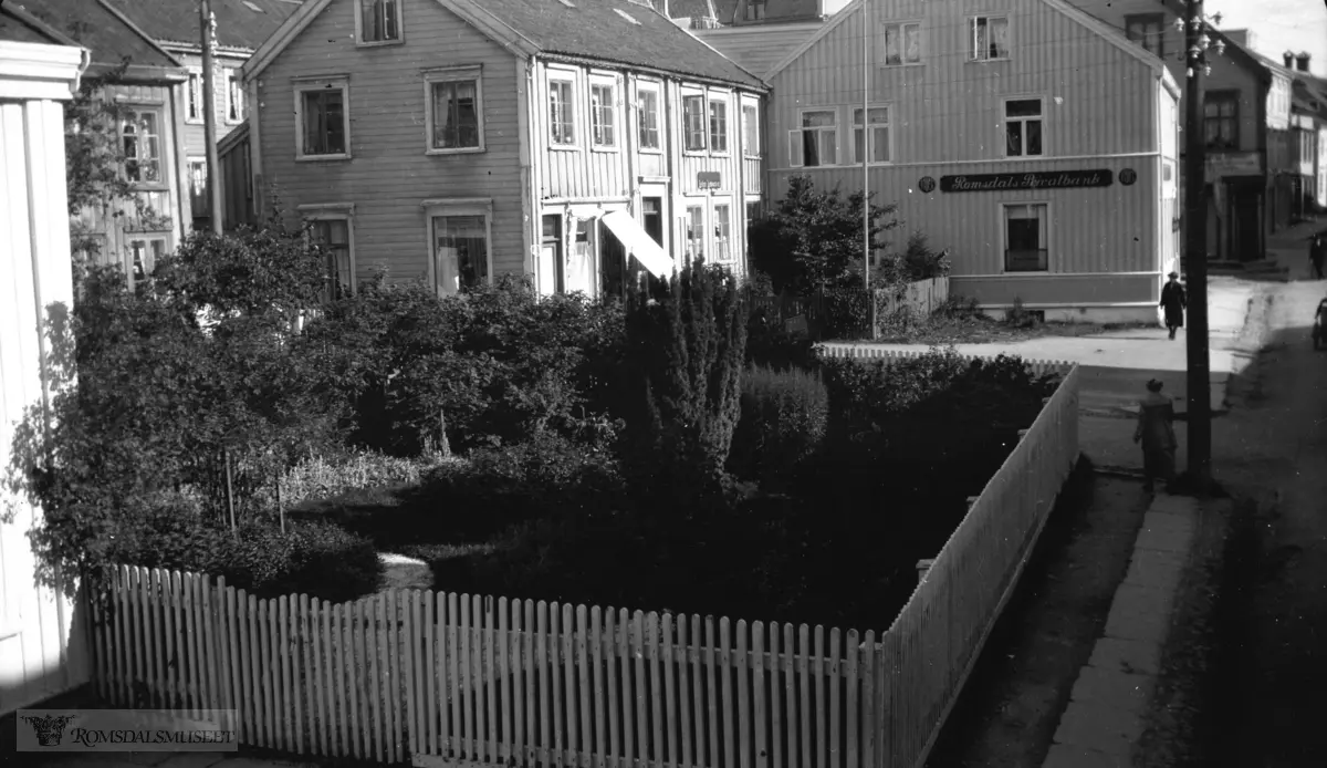 Storgata sett østover.I Sættemgården..Kjøpmannsgården til Harald Eide hus med hage til venstre..Lovise Lunds hus..Romsdal Privatbank oppstart i 1916 avviklet i 1934.