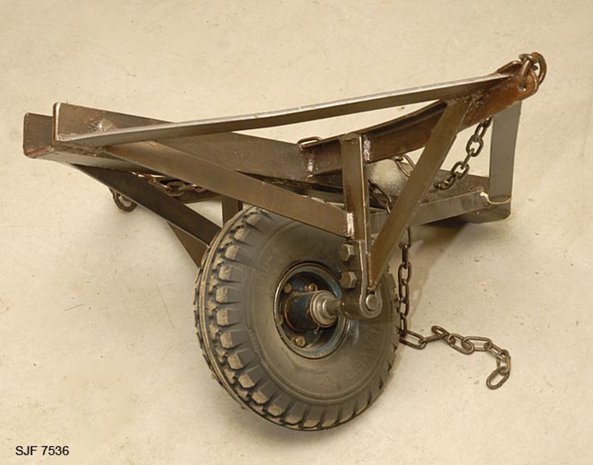 Båttralla har en firkantet jernramme med et spor til kjølen. Den har et hjul. 