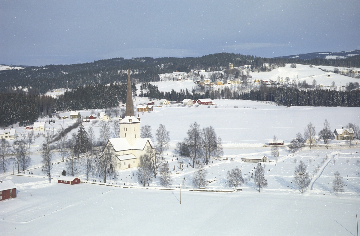 Flyfoto av Ringsaker kirke og omegn. Ringsaker Folkehøgskole i bakgrunn. Vinter.