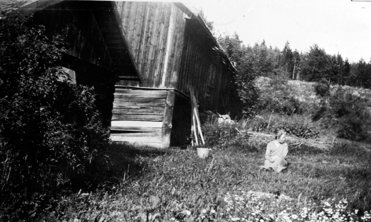 Maurud øvre, Helgøya. Trine Vestgård i gresset bak uthuset.