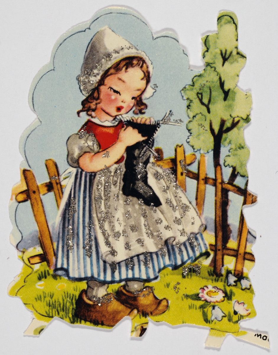 Bilde av en jente som holder et strikketøy i hendene. Hun har et hollandskinspirert antrekk på seg. Bak henne er det et gjerde.