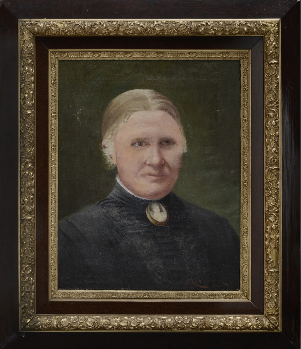 Portrett
Kvinne i sort drakt med pyntenål i halsen