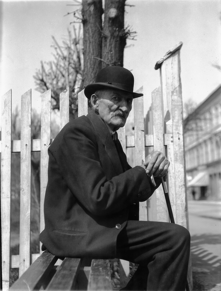 Eldre mann på en benk i Strandgata, Hamar. 