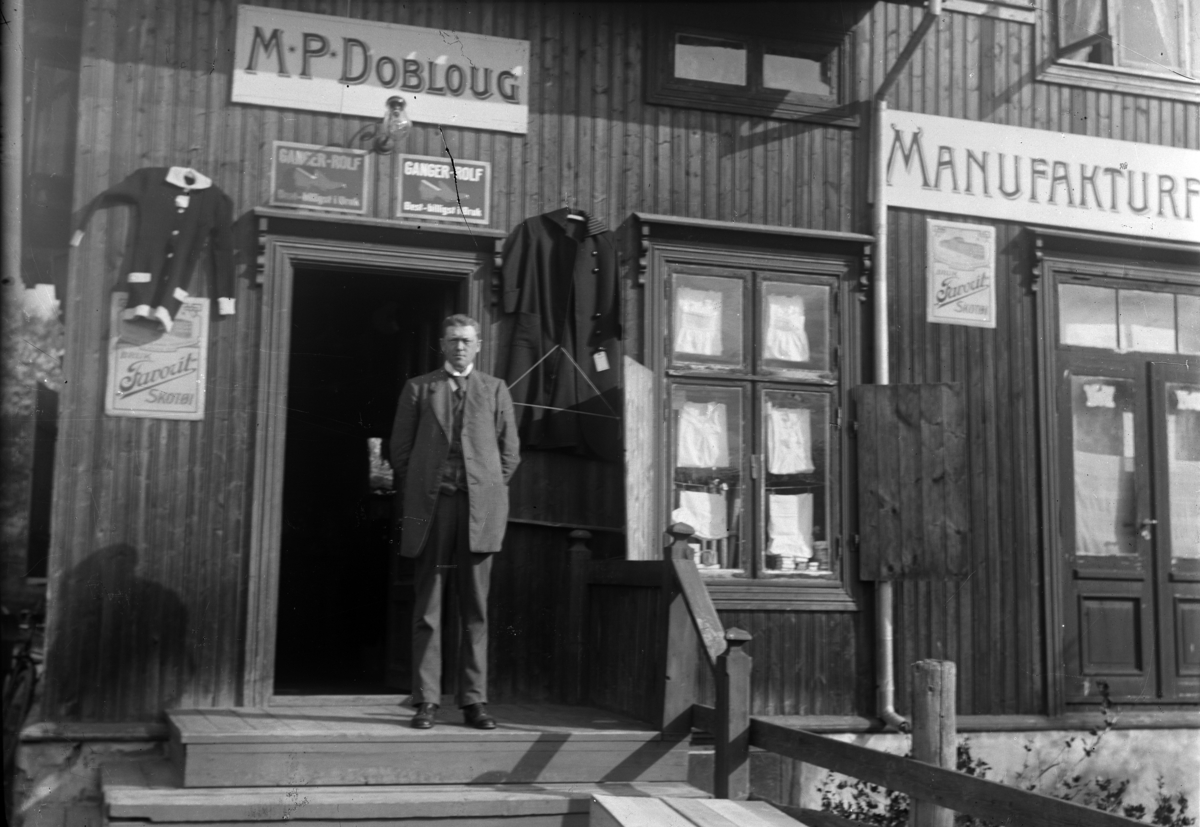 Ringsaker, Moelv, Mikkel P. Dobloug på trappa foran sin manufakturforretning, 
M. P. Dobloug, åpnet sin første forretning i kobberslager Ruds gård 4. mai 1911, flyttet til apotekergården/Doblouggården i Storgata i 1916,
