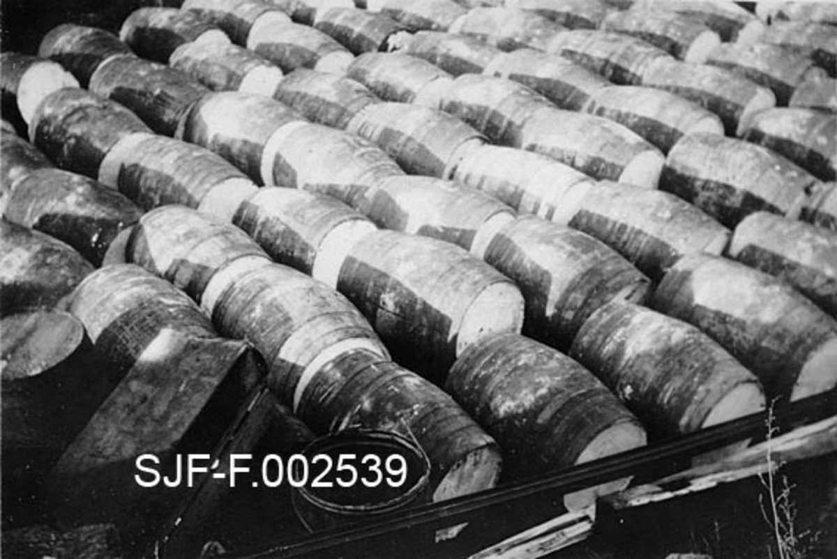 Lager av tønner (trefat) ved det fabrikkanlegget til Schwencke & Co's Eftf. bygde på Børsholmen i Asker i 1924.  Schwencke & Co. var et firma som produserte og forhandlet bek og andre tjærebaserte substanser, først og fremst for et maritimt marked.  Det er rimelig å tro at tønnene, som ligger tett sammen på rekker, kan ha inneholdt slike produkter.  Nettopp i 1924 ble mye av produksjonen flyttet fra Kongshavn sør for Oslo til Børsholmen, hvor den ildsfarlige virksomheten kunne drives i betryggende avstand i forhold til annen bebyggelse. Den 9. februar 1938 oppsto det brann i tjærefabrikken på Børsholmen. En «bekkoker» kokte over og den varme massen rant nedover mot lavereliggende lagerskur. Der antente den lagerbygningen og beholdningen.